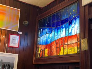The colourful lightbox with regulars' faces on the wall at Grogan's