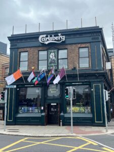 Exterior of The Bleeding Horse: flags, Carlsberg branding and a portrait of a horse